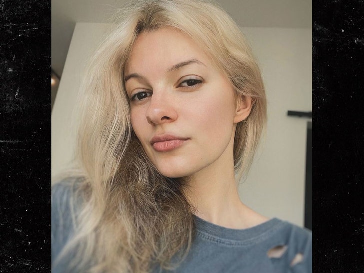 Iryna Zarutska is seen while posing for a photo. She's wearing a torn-up gray t-shirt.