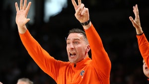Steven Pearl is seen at an Auburn University basketball game. He's wearing a bright orange half-zip sweater.