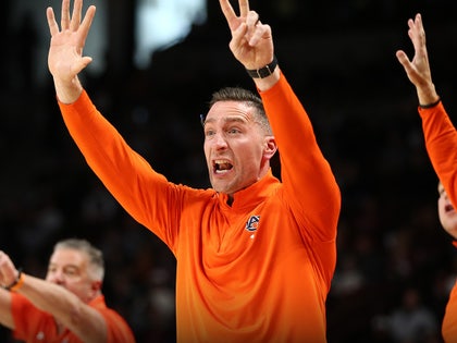 Steven Pearl is seen at an Auburn University basketball game. He's wearing a bright orange half-zip sweater.