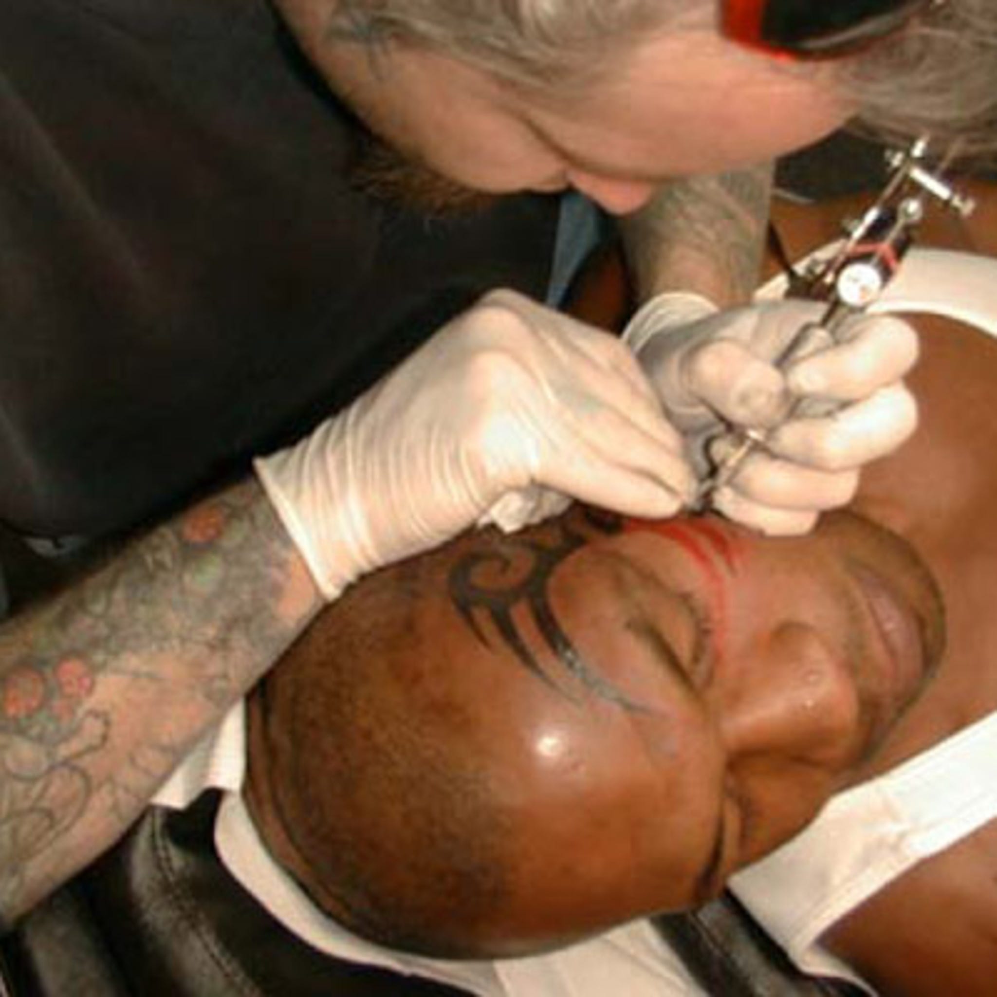 Mike Tyson tattoo on the right upper arm.