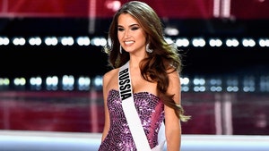 Model Kseniya Alexandrova is seen competing in a beauty pageant. She's wearing a sequin-covered dress and a white sash with the word 