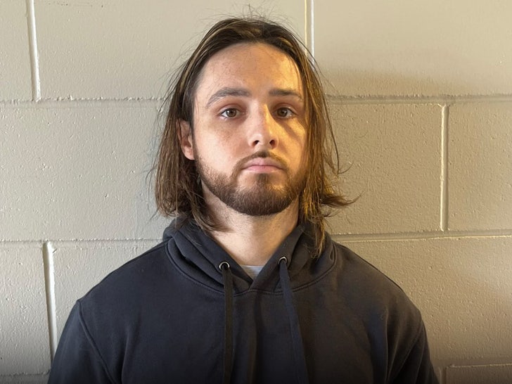 Jonathan Rinderknecht is seen posing for a mugshot. He's wearing a black hoodie.