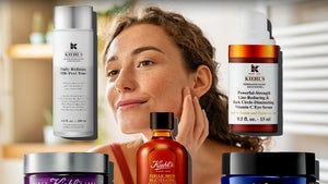 Woman Looking At Her Face Surrounded By Kiehl's Beauty Products