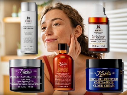 Woman Looking At Her Face Surrounded By Kiehl's Beauty Products