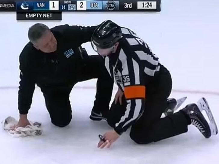 Justin Kea NHL Wasit membawa keping ke bola selama pertandingan Canucks-utah