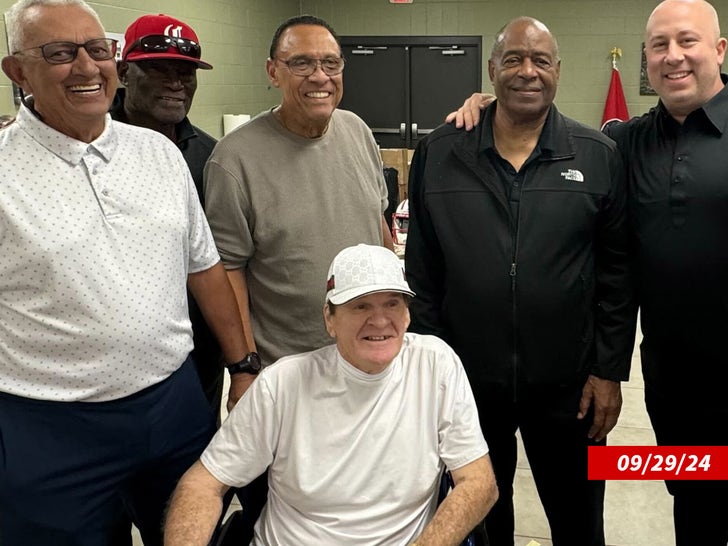 Das am 29. September 2024 aufgenommene Bild zeigt Pete Rose, wie er mit weißem Hut und weißem T-Shirt vor Dave Concepcion, George Foster, Tony Perez, Ken Griffey Sr. und einer fünften Person sitzt.