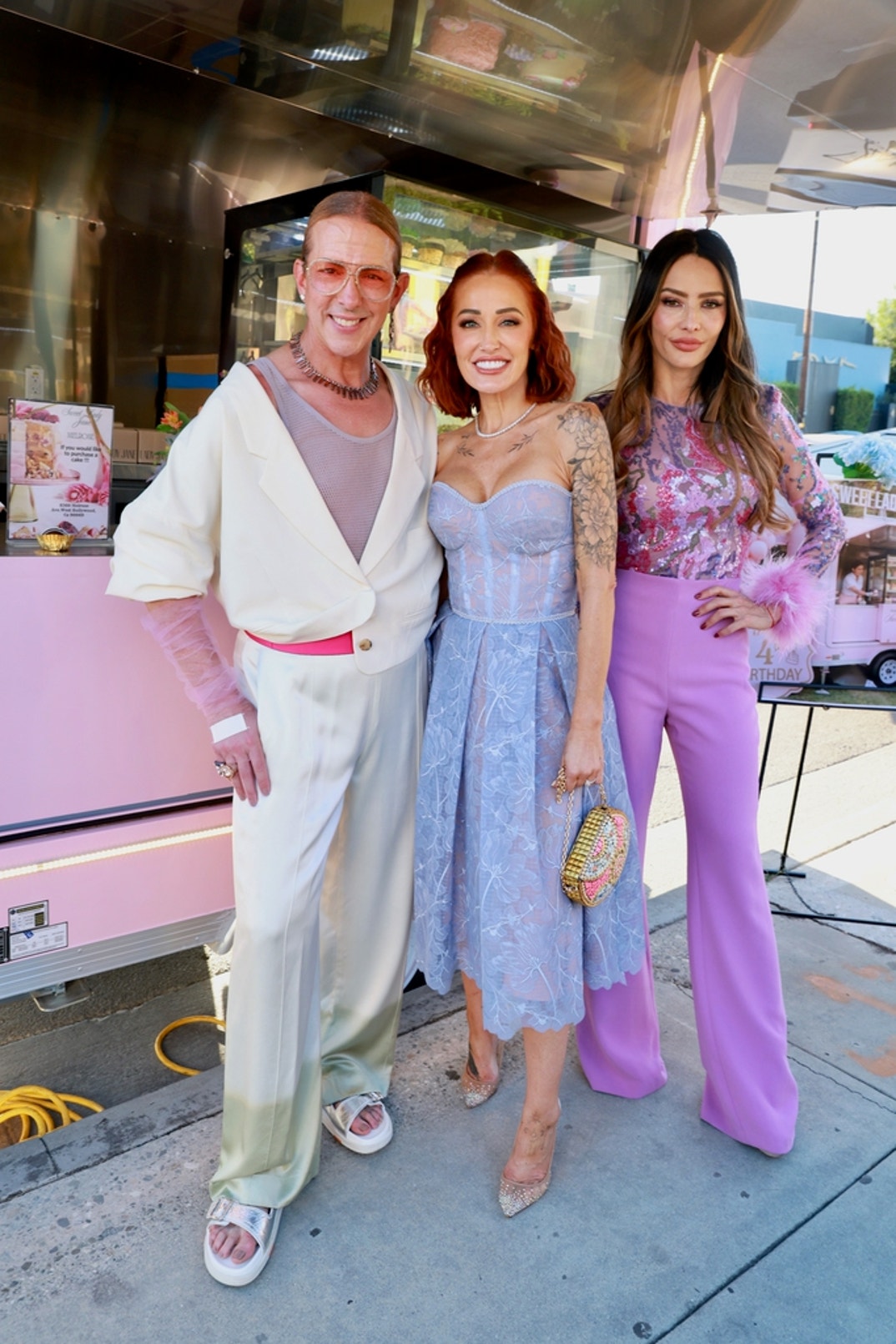 Hosts Mary Bonnet and Sandra Vergara pose with Gurus Media Founder, Publisher, and Editor-in-Chief Derek Warburton at the Sweet Lady Jane dessert experience at Bloom Boom Boutique Florist during the 2026 Gurus Beauty Soirée in Los Angeles. Warburton wears a natural diamond and tourmaline necklace and matching earrings by Ford Swift.
