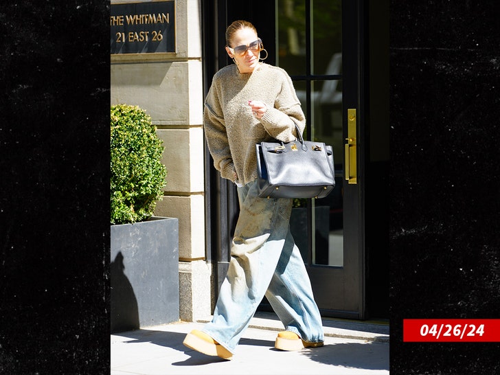 Jennifer Lopez walking out of a building wearing baggy jeans, sunglasses, hoop earings on the day of her separation from Ben Affleck.