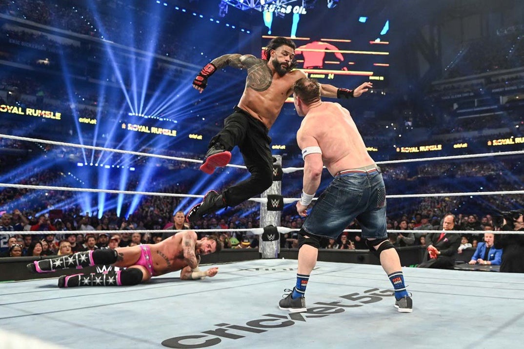 Roman Reigns superman punch to John Cena as CM Punk slowly recovers.