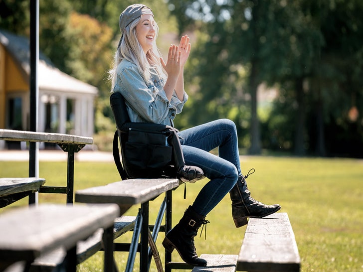 girl clapping on bleachers outside