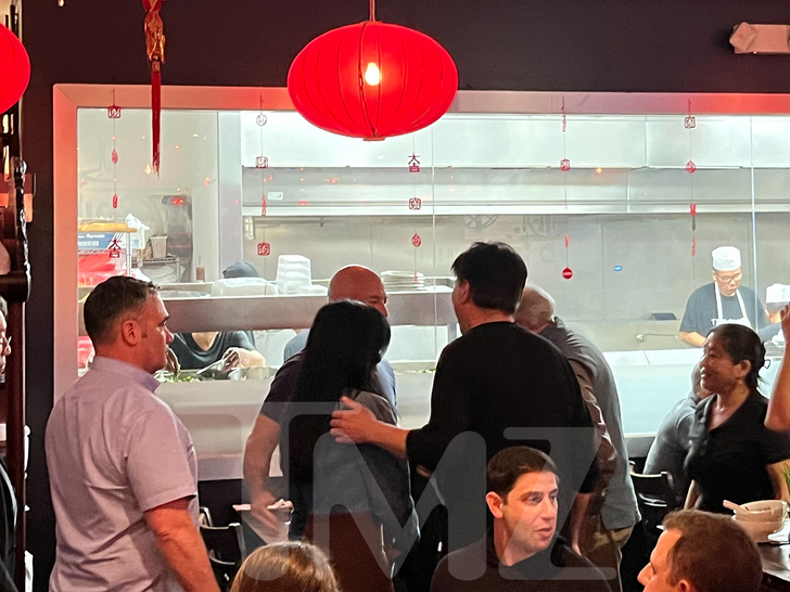 Jeff Bezos and Lauren Sanchez standing near people in Miami restaurant.