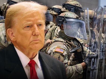 Donald Trump's looking concerned in front of a few National Guard members. He's wearing a black jacket, white shirt, and red tie.