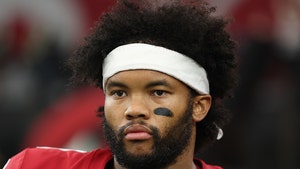 Kyler Murray is seen at a football game. He's wearing a red jersey and a white headband, and he has a patch of black face paint on his left cheek.