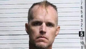 Nigel Edge is seen posing for a mugshot. He's wearing a black sweater.