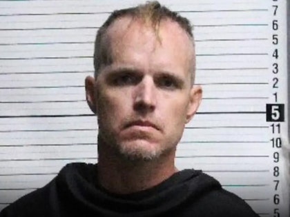 Nigel Edge is seen posing for a mugshot. He's wearing a black sweater.