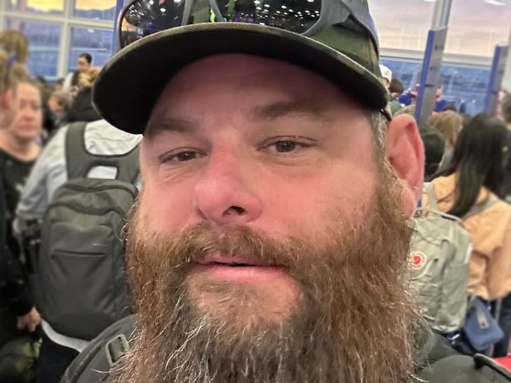 Syko Stu's seen in an apparent selfie. He's got a pair of sunglasses perched on the brim of his hat.