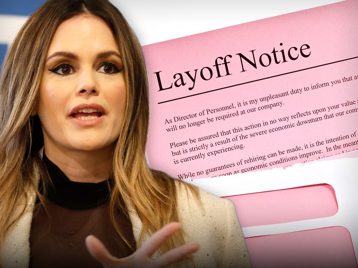 Rachel Bilson's looking concerned in front of a layoff notice. She's wearing a black sheer top and a white coat.