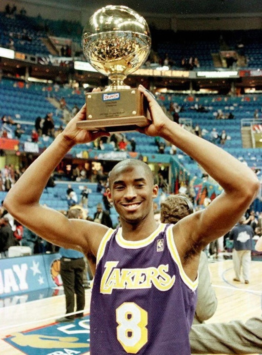 Download Kobe Bryant with a championship trophy.