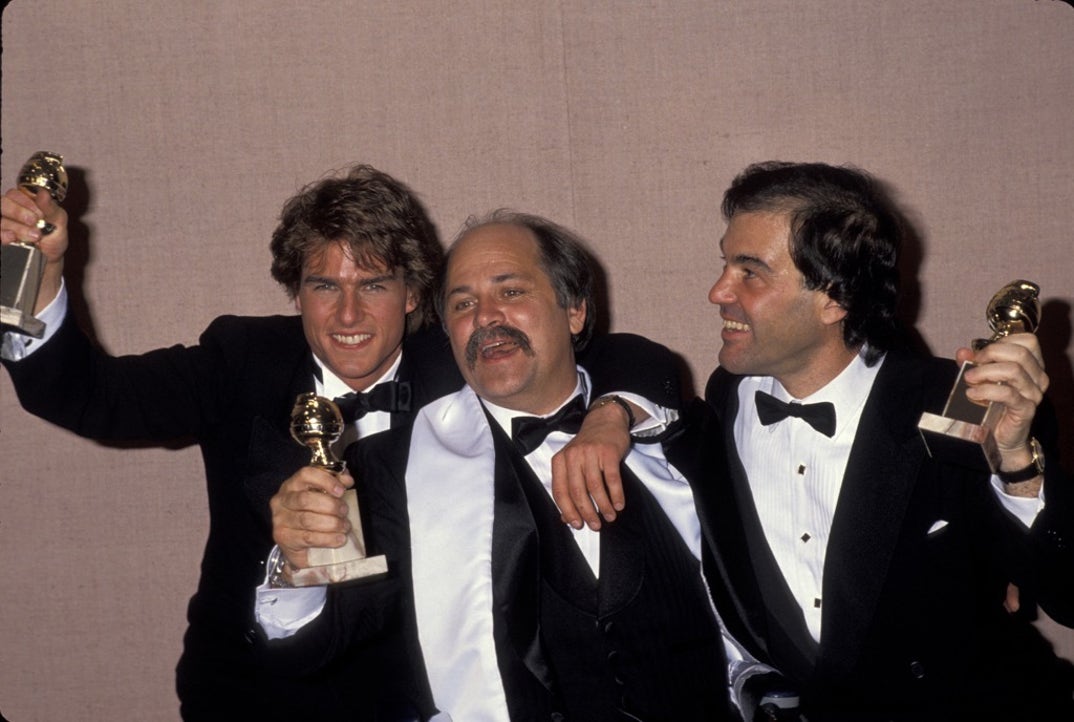 1990 -- Actor Tom Cruise (L), writer Ron Kovic (C) and Director Oliver Stone celebrate winning Golden Globe Awards for the film 