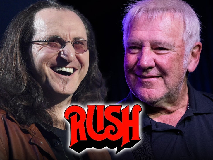 Geddy Lee and Alex Lifeson are smiling behind Rush's logo. Lee's wearing a brown jacket and a black t-shirt, while Lifeson's wearing a black button-up shirt.