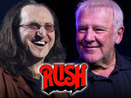 Geddy Lee and Alex Lifeson are smiling behind Rush's logo. Lee's wearing a brown jacket and a black t-shirt, while Lifeson's wearing a black button-up shirt.
