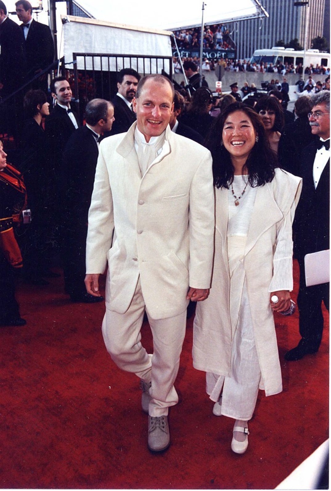 1997 -- Actor Woody Harrelson and his partner, businesswoman Laura Louie, both dress in white-and-ivory outfits at the 54th Golden Globe Awards.