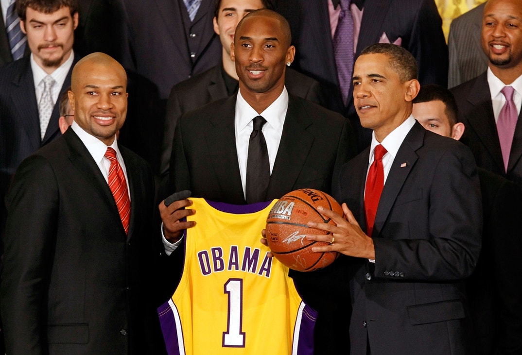 President Barack Obama (R) poses for photographs with Kobe Bryant (C), Derek Fisher and members of the National Basketball Association 2009 champions Los Angeles Lakers in the East Room of the White House January 25, 2010 in Washington, DC. The Lakers bested the Orlando Magic to win the NBA Finals in 2009.