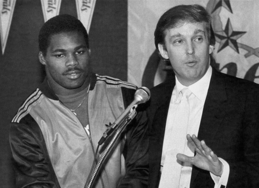 Herschel Walker, NJ Generals Running Back, looks on as Donald Trump, NJ Generals Owner, makes the announcement of a new contract for Herschel Walker through the 1989 season during a press conference.