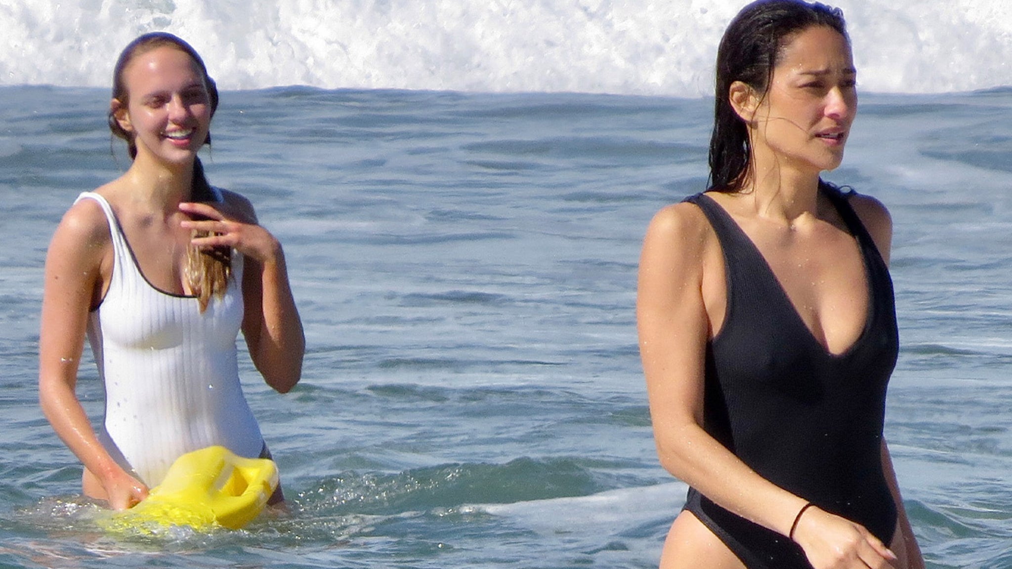 Shay Mitchell in black swimsuit during Baywatch 2026 beach training with yellow rescue board in Los Angeles