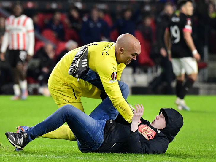 Pitch entrant in combat with Marko Dmitrovic of Sevilla FC