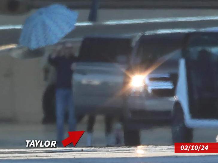 tayor swift arrives to lax  under umbrella