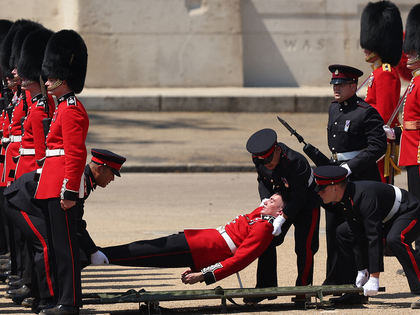 Grenadier Guards is carried after fainting during the Colonel's Review