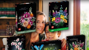 Mother And Son Smiling At A Table Surrounded By LEGO Kits