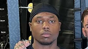 Raja Jackson's seen standing next to a friend in a gym. He's wearing a black t-shirt and a matching durag.