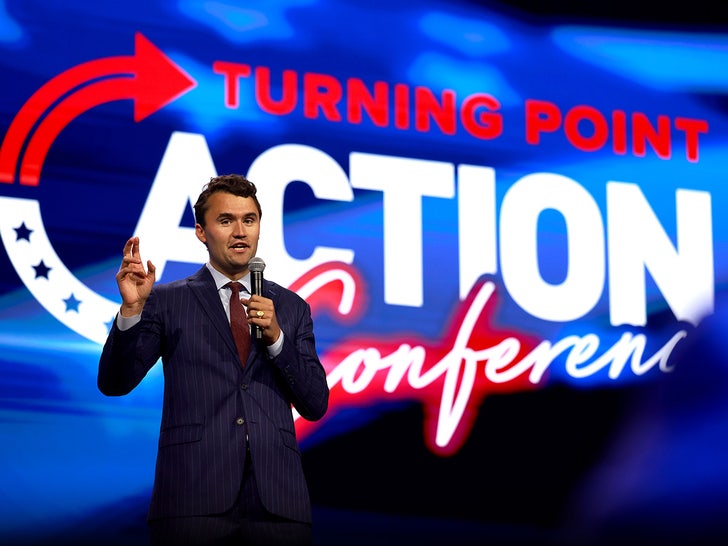 Charlie Kirk is seen standing in front of a screen with a 