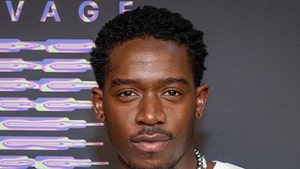 Damson Idris is seen at what appears to be a premiere event. He's wearing a white t-shirt and a pair of necklaces.