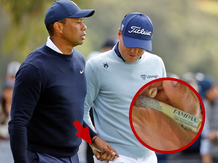 Tiger Woods handing Justin Thomas tampon
