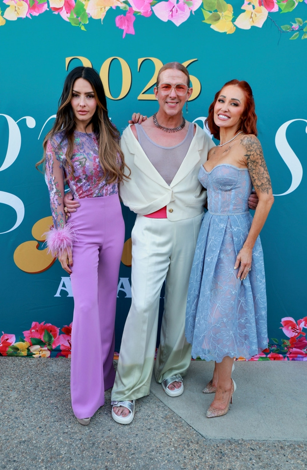 Hosts Mary Bonnet and Sandra Vergara pose with Gurus Media Founder, Publisher, and Editor-in-Chief Derek Warburton at the Sweet Lady Jane dessert experience at Bloom Boom Boutique Florist during the 2026 Gurus Beauty Soirée in Los Angeles. Warburton wears a natural diamond and tourmaline necklace and matching earrings by Ford Swift.