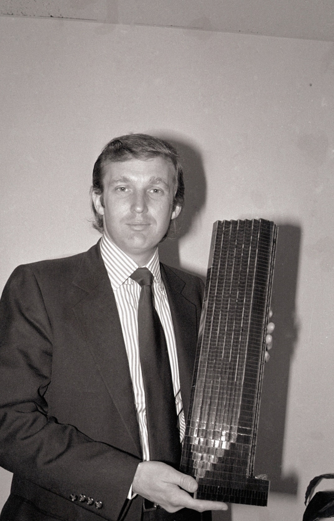 Donald Trump, 33-year-old golden boy of New York real estate, holds a model of the Fifth Avenue tower that will have shops, offices and co-ops. One of the apartments would sell for $11 million and he claimed four bidders -- none of them Americans -- are bidding for it.