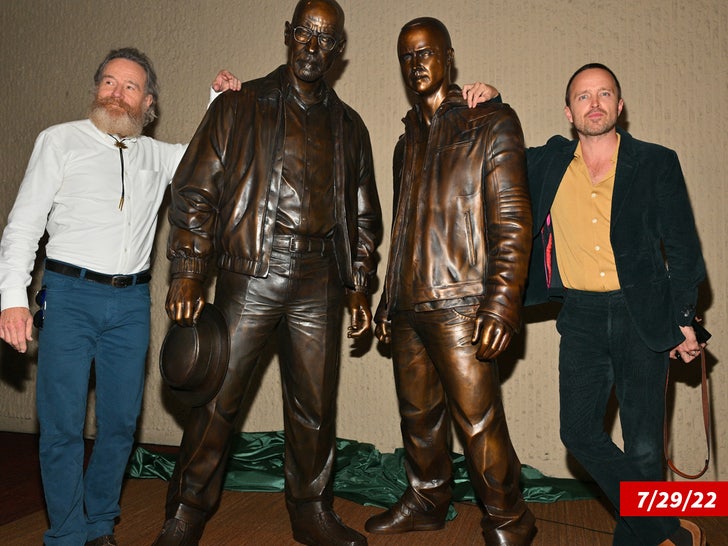 Bryan Cranston Aaron Paul pose with bronze statues