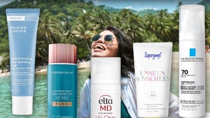 A Woman On The Beach Surrounded By Sunscreens