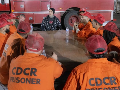 Travis Barker Sitting At A Table With Incarcerated Firefighters