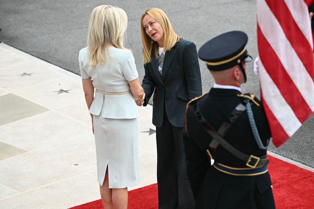 Italian Prime Minister Giorgia Meloni is greeted by US Chief of Protocol Monica Crowley (L) upon arrival at the White House
