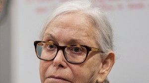 Donna Adelson is seen in a courtroom. She's wearing glasses, a blue shirt, and a black jacket.