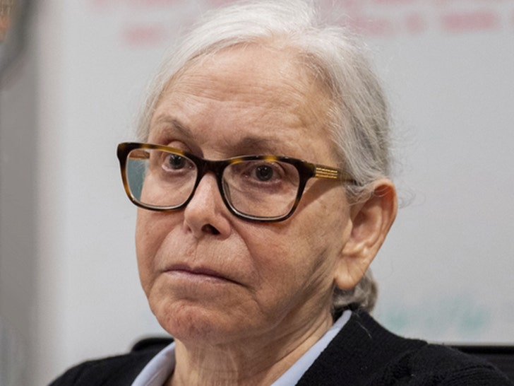 Donna Adelson is seen in a courtroom. She's wearing glasses, a blue shirt, and a black jacket.