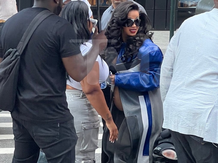 Cardi B covered by team walking through NYC