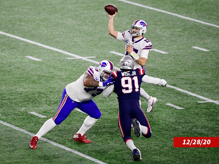 Josh Allen #17 memberikan umpan saat rekan setimnya Dion Dawkins #73 dari Buffalo Bills memblokir Deatrich Wise #91 dari New England Patriots