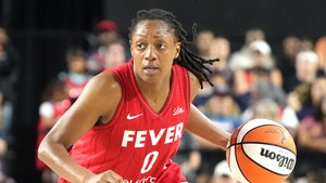 Kelsey Mitchell is seen during an Indiana Fever game. She's wearing a red-and-white jersey, as well as matching athletic shorts.