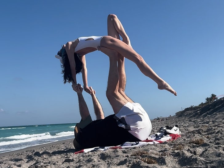 Bill Belichick, GF Jordon Hudson realizar acrobacias acrobáticas é praia