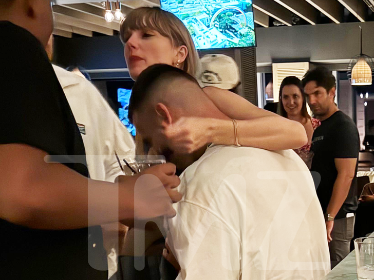 Taylor Swift Wraps Arms Around Travis Kelce in First PDA Shots